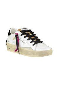 Sneaker en cuir blanc avec accents dorés, lacets noirs et semelle texturée beige. Présente une étiquette rose et des détails noirs sur le talon.
