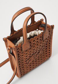Wpleciona brązowa torba na ramię z podwójnymi uchwytami, posiadająca teksturowany wzór i kremowe wnętrze. Zawiera odpinany pasek na ramię.