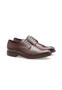 Scarpe di pelle marrone con una finitura liscia, dotate di una punta arrotondata e un sistema di allacciatura, posizionate su una suola in gomma nera con dettagli sottili.