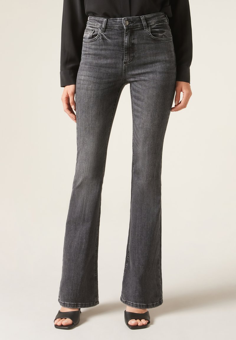 Jean flair noir avec taille haute, en denim. Comprend des poches avant et une texture légèrement décolorée, avec une taille ajustée et des jambes plus larges.