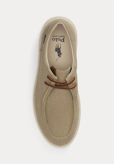 Bež platnen sandal z rjavimi usnjenimi vezalkami, predelom prstov s šivi in logotipom "Polo Ralph Lauren", ki je viden znotraj čevlja.