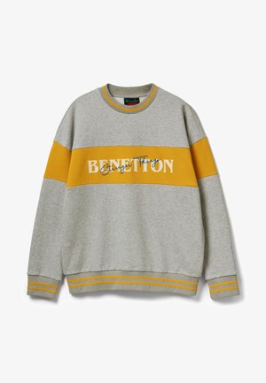 Felpa grigio chiaro con una larga striscia gialla senape sul petto e sulle braccia, con la scritta "Benetton Stranger Things" in bianco e blu.