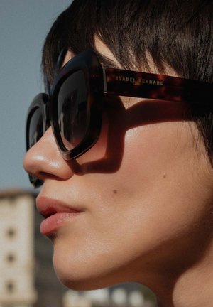 schildpadvormige zonnebril met oversized, hoekige glazen. Het montuur heeft een glanzende afwerking en de poot is gegraveerd met "ISABEL BERNARD."