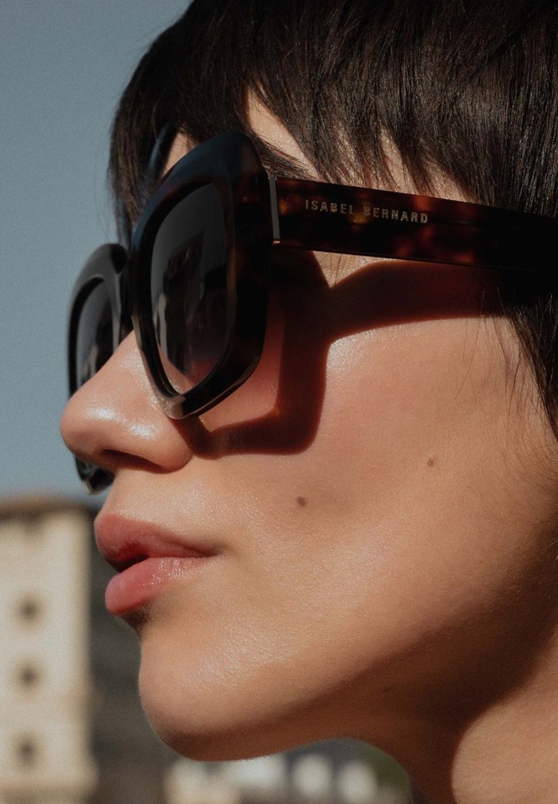 schildpadvormige zonnebril met oversized, hoekige glazen. Het montuur heeft een glanzende afwerking en de poot is gegraveerd met "ISABEL BERNARD."