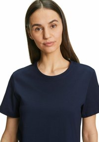 T-shirt a maniche corte blu navy in cotone. Presenta un collo rotondo e una texture semplice e liscia senza motivi o decorazioni visibili.