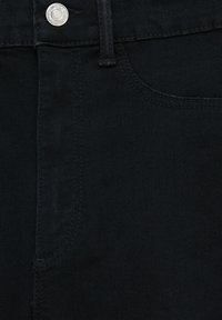 Jeans de mezclilla negra con una textura suave, que presentan un bolsillo frontal, passantes para cinturón y un cierre de botón metálico.