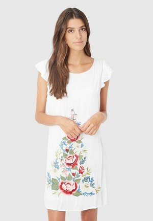 Vestido blanco con bordado floral en rojo, rosa, azul y verde. Mangas cortas con volantes, corte relajado, diseño hasta la rodilla.