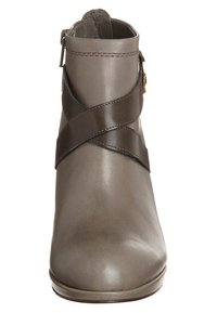 Bottine en cuir gris à texture lisse, dotée d'une sangle marron croisée et d'une fermeture éclair latérale. Design à bout arrondi.