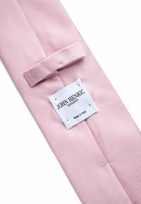 Rosa slips med diagonala ränder, tillverkad av slätt tyg, med en etikett som säger "John Henric" och noterar "Tillverkad i Italien."