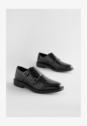 Čierne kožené spoločenské topánky s dvoma nastaviteľnými prackami, hladkým povrchom, zaoblenou špičkou a nízkym stohovaným podpätkom.