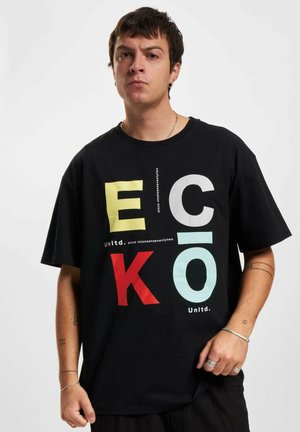Sort bomulds t-shirt med store flerfarvede bogstaver "E," "C," "K," og "O." Rund halsudskæring, afslappet pasform, med tekstdetaljer under grafikken.