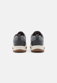 Szare buty sportowe z teksturowaną cholewką z materiału canvas i ciemnymi syntetycznymi akcentami. Posiadają amortyzującą podeszwę środkową oraz gumową podeszwę dla lepszej przyczepności.