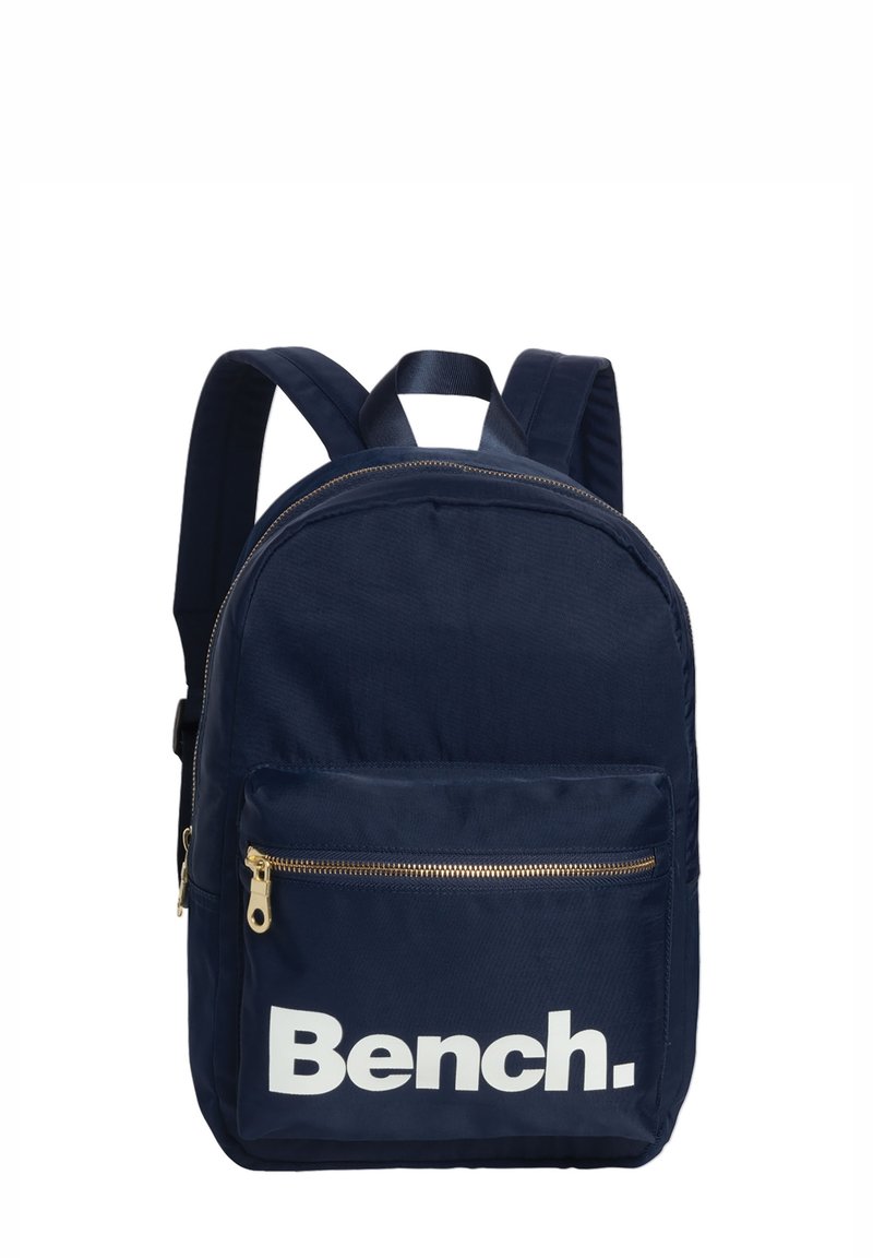 Sac à dos bleu marine en tissu ; comprend un grand compartiment principal, une poche avant zippée, et le logo blanc "Bench." sur le devant.