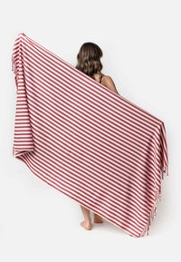 Rood-wit gestreepte deken met franjes, weergegeven in een vloeiende draping. Gemaakt van zachte, gestructureerde stof.