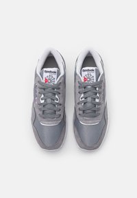Graue Sneakers aus einer Mischung von Wildleder und Netzmaterialien, mit einem weißen Rand um die Zehenpartie, flachen grauen Schnürsenkeln und einem gepolsterten Schaft.