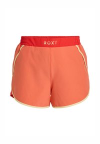 Roxy zwemshorts in koraal met een rode elastische tailleband; heeft een gele rand langs de zoom en zijzakken. Glad, lichtgewicht materiaal.