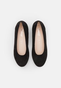 Ballerines en suede noir avec un bout arrondi et un design minimaliste. Doublure intérieure douce et marque subtile visible sur la semelle intérieure.