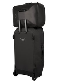 Maleta rodante de tela negra, con un mango telescópico y dos ruedas. La sección superior es una bolsa desmontable, ambas con un diseño elegante.