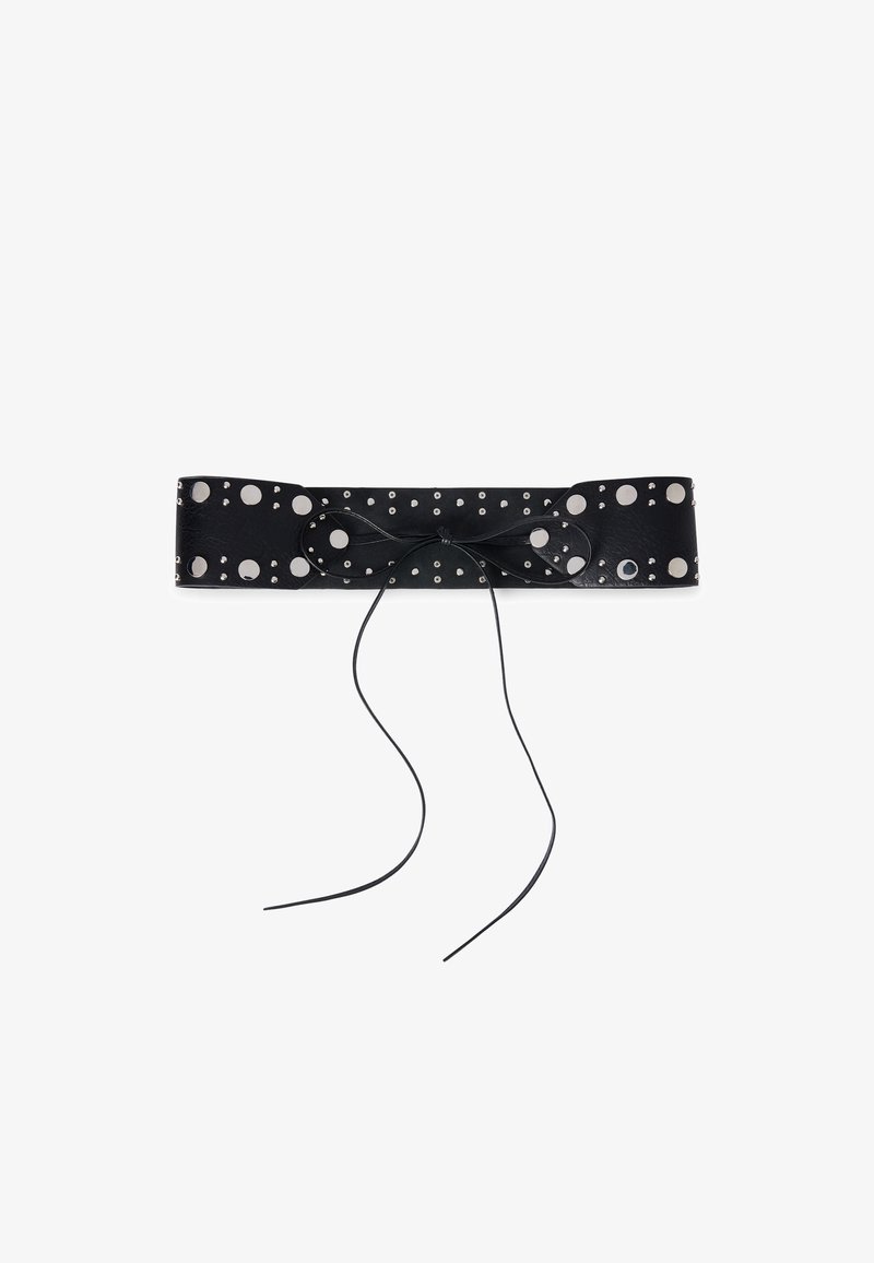 Cintura in pelle nera con grandi borchie circolari in argento, caratterizzata da un dettaglio a fiocco annodato al centro. Texture liscia, forma piatta e rettangolare.