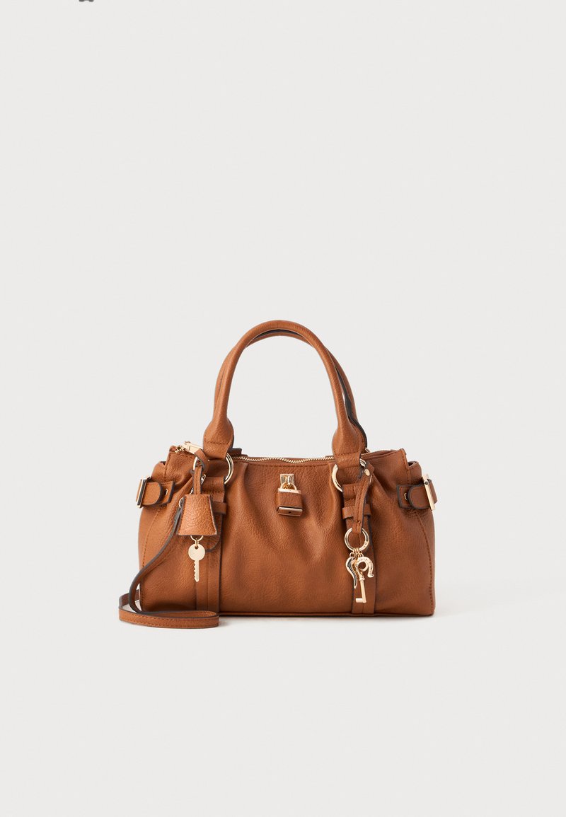 Braune Lederhandtasche mit doppelten Griffen, verstellbarem Schulterriemen, goldfarbenen Beschlägen, Reißverschluss und einem Schlüsselanhänger im Detail. Glatte Textur.