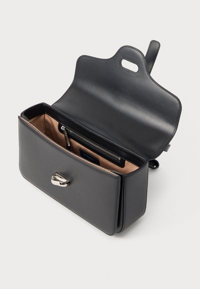 Μαύρο δερμάτινο τσαντάκι ώμου με ανοιχτό καπάκι, δείχνοντας μπεζ υφασμάτινη εσωτερική επένδυση και εσωτερική τσέπη με φερμουάρ, ασημί κούμπωμα με περιστρεφόμενο κλείσιμο στο μπροστινό μέρος.