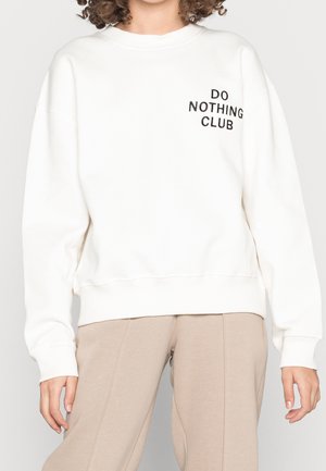 Sudadera blanca con puños y dobladillo acanalados, que presenta el texto negro "DO NOTHING CLUB" en la parte delantera. Material suave con un corte relajado.