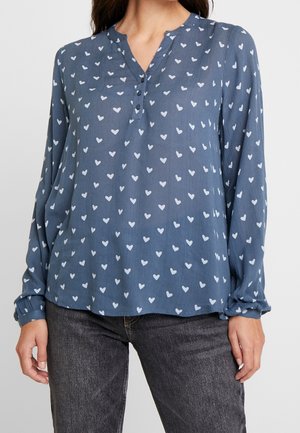 Blusa de manga larga con botones en azul pizarra con patrón de corazones blancos. Tela suave y ligera con un ajuste relajado y mangas fruncidas.