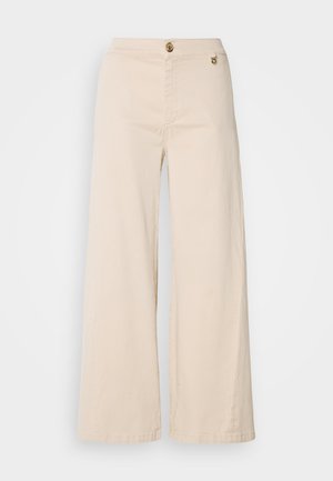 Beige vide bukser laget av bomull. Har en frontknappelukking og sidelommer. Jevn tekstur med et rent, minimalistisk design.