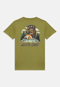 Olivgrön T-shirt med en stor grafik av en björnpaw, ett tält, träd och moln, med texten "Santa Cruz" längst ner.