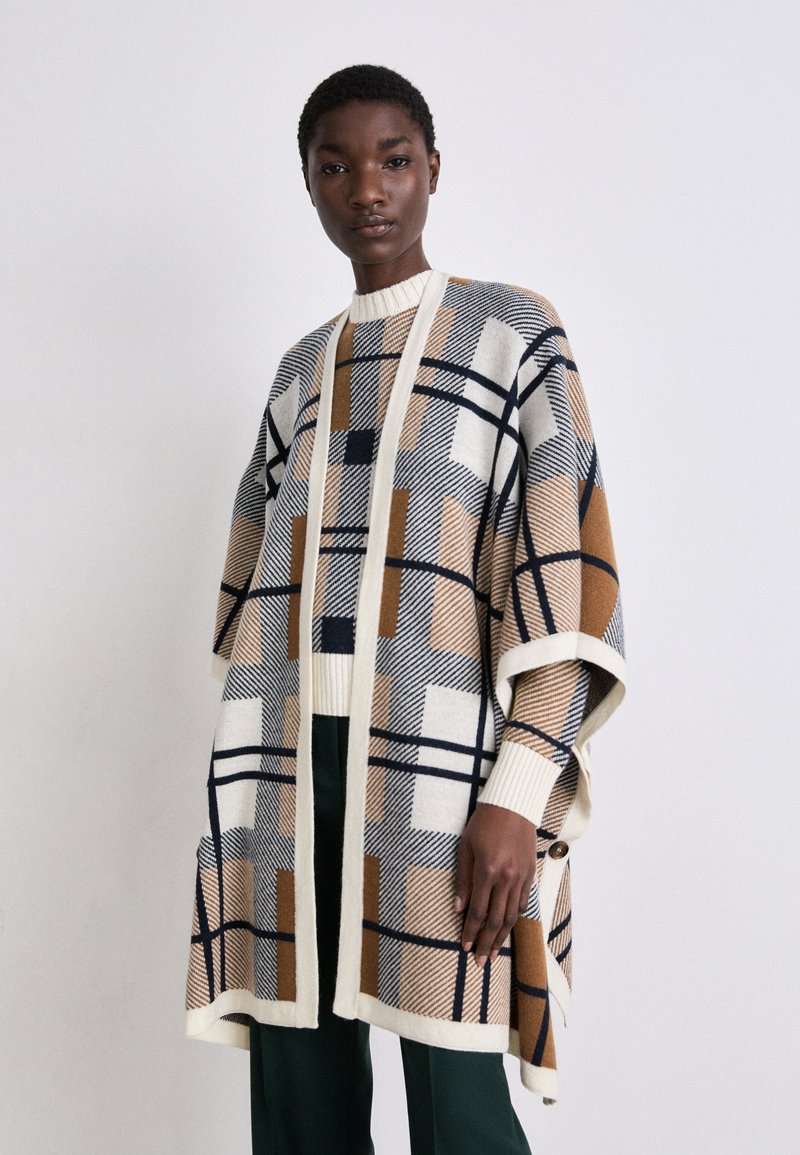 Poncho tricotat în tonuri neutre cu modele geometrice, având un guler tip șal, deschidere frontală și mâneci îndoite; material moale, texturat.