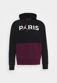 Sweat à capuche avec un haut noir et un panneau inférieur bordeaux, avec le texte « PARIS » et le logo Jordan en blanc. Fabriqué en tissu doux avec des poignets côtelés.