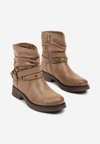 Bottes en cuir couleur tan arrivant au mollet avec tige en tissu froncée, sangles décoratives avec clous en métal, zip latéral et petit talon empilé.
