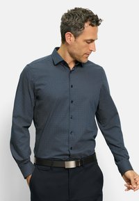 Dunkelblaues Langarmhemd mit kleinem geometrischem Muster, Button-Down-Kragen und schwarzem Gürtel mit metallischem Verschluss.