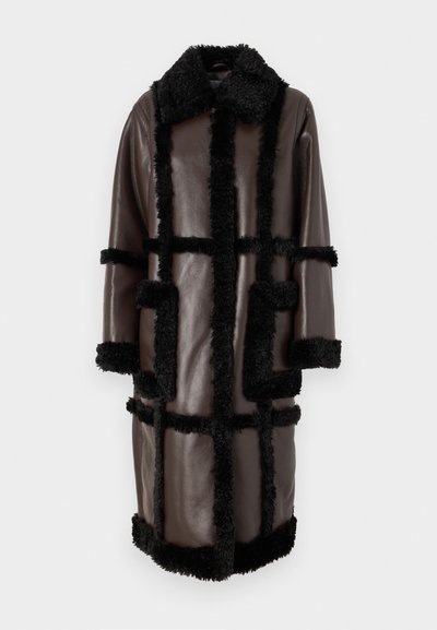 Brun läderjacka med svart fårskinnsdetalj, krage, långa ärmar och två framfickor med rutmönster.