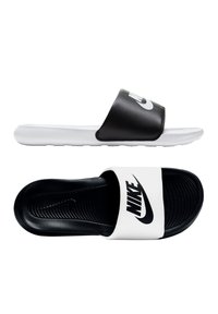 Svart og hvite sandaler med bred stropp som har Nike-logoen. Teksturert innleggssåle og slitesterk såle for godt grep.