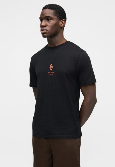 Black crewneck t-shirt made of cotton, featuring a central orange diamond logo and text. Short sleeves and a relaxed fit.