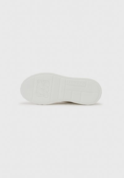 Vit sneakersula i texturerad gummi, med en upphöjd logotyp och mönstrat grepp. Släta kanter och platt design för stabilitet.