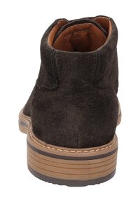 Stivali ankle in suede marrone scuro con design arrotondato, fodera in pelle color tan e suola in gomma testurizzata con accenti stratificati.