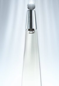 Klar glass parfymeflaske med en avsmalnet form, metallisk sølvhette med en sfærisk topp, og et minimalistisk design.