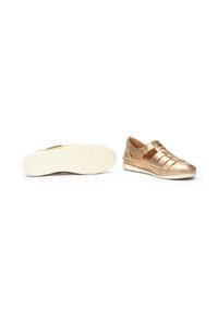 Zapatos metálicos dorados tipo slip-on con diseño de tejido en la parte superior, interior acolchado y suela de goma texturizada blanca. Punta redondeada y correas elásticas.