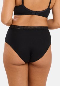 High-waisted black panties with a smooth texture, featuring a decorative lace trim along the waistband and full coverage at the back.