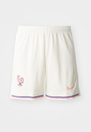 Valged sportlikud lühikesed püksid, millel on tekstuuriga kangas, kanaembleem ja kontrastsed sinised ja punased triibud allääres. Nike logo virsiku värvuses.