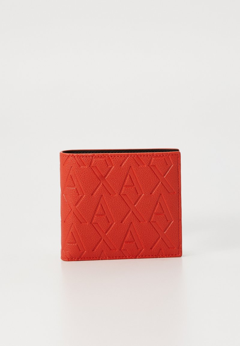 Raudonas odinis piniginė su iškiliais geometriniais raštais ir kontrastinga juoda vidine dalimi. Stačiakampio formos, lygus paviršius, kompaktiškas dizainas.