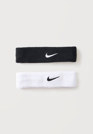 Fasce sportive Nike nere e bianche con loghi Swoosh a contrasto su uno sfondo chiaro uniforme.