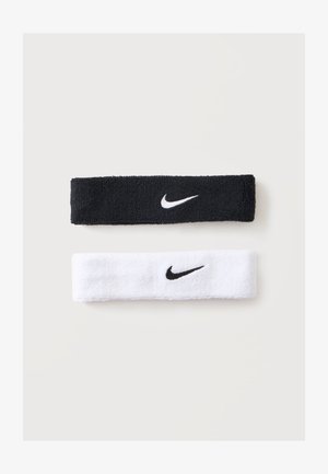 Bandeaux de sport Nike noirs et blancs avec logos Swoosh contrastants sur un fond clair uni.