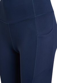 Mørkeblå leggings lavet af strækbart stof, med bred linning og sidelomme, flade syninger og en glat tekstur.