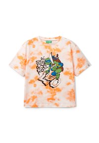 Camiseta blanca con patrón de tie-dye naranja que presenta un gráfico de un personaje de tortuga sosteniendo una espada, etiquetado como "Turtle Power". Manga corta.