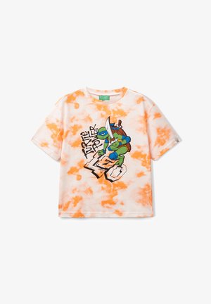 Camiseta blanca con patrón de tie-dye naranja que presenta un gráfico de un personaje de tortuga sosteniendo una espada, etiquetado como "Turtle Power". Manga corta.