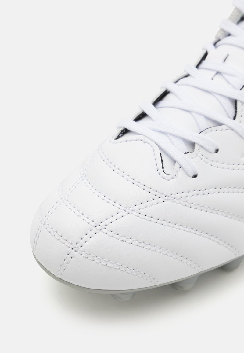 Crampons de soccer blancs avec un dessus en cuir texturé, un matelassage en coutures, des lacets plats et une semelle grise avec plusieurs crampons.