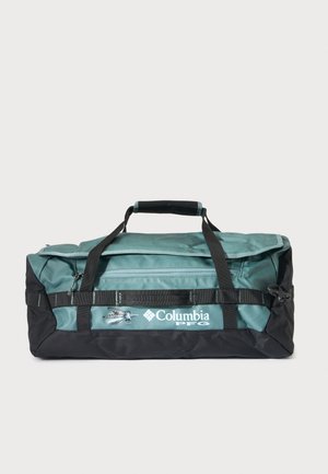 Πράσινη και μαύρη τσάντα Columbia PFG duffel με πάνω λαβές και μπροστινή τσέπη με φερμουάρ σε απλό φόντο.
